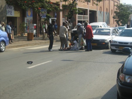 A woman knocked down by a motorist at a zebra crossing holds tight to her baby until she is helped up by memmbers of the public. Police are deployed to monitor jaywalking and enforce crossing at designated points like this one in the byzzy city streets. But motorists don't even respect the zebra crossings. Meanwhile, thugs have a field day in the rural areas of Swaziland.