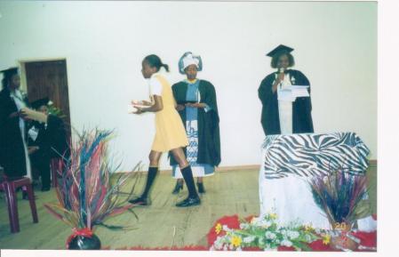 A female lawyer for human rights (middle) hands awards to outstanding students at a school's prize day. 